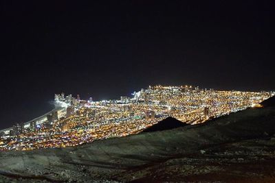 Illuminated cityscape against sky at night