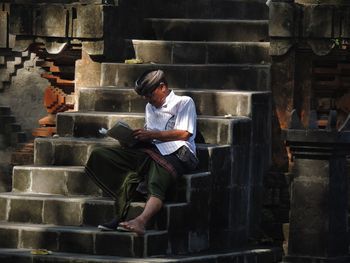 Man using mobile phone while sitting outdoors