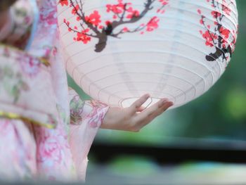 Midsection of woman holding paper lantern