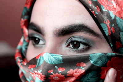 Close-up of woman with gray eye shadow wearing headscarf