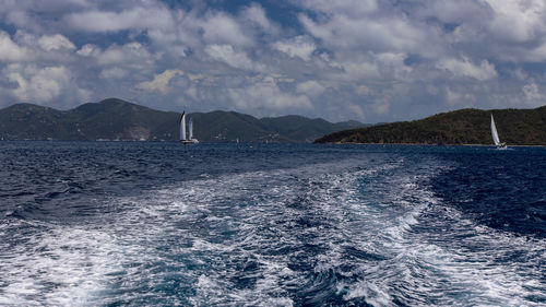 Sailboat sailing on sea against sky