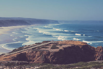 Scenic view of sea and mountains against clear sky