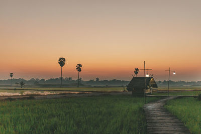 Scenic view of farm against sky during sunset