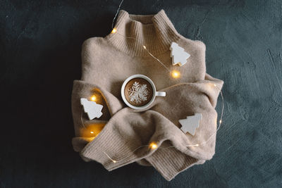 Christmas cup of coffee with sweater and christmas decorations.