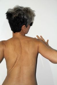 Rear view of shirtless woman against white background