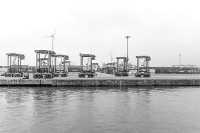 Pier at harbor against clear sky