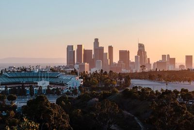 Buildings in city against sky during sunset