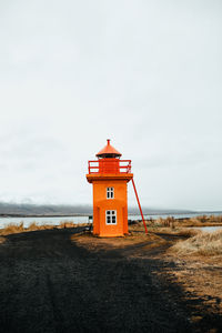 Lighthouse by sea against sky