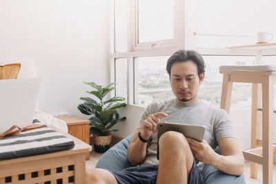 Man using digital tablet siting on beanbag