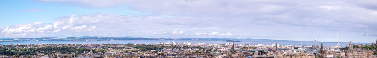 Panoramic view of city by sea against sky