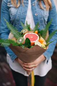 High angle view of woman holding fruit bouquet