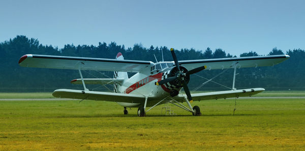 Airplane on field against clear sky