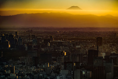 High angle view of illuminated cityscape against sky during sunset