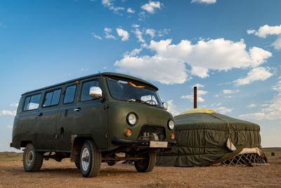 Vintage car on land against blue sky