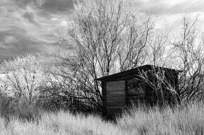 Abandoned house on field against sky