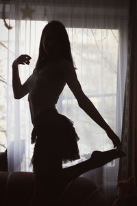 Woman dancing by window at home