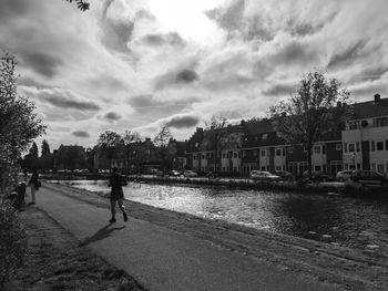 Man walking on road against sky in city