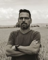 Portrait of young man standing on field