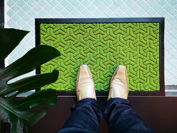 Low section of man standing on doormat