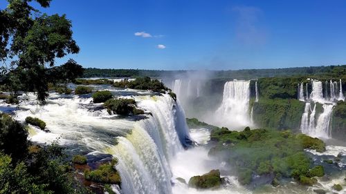 Scenic view of waterfall against sky