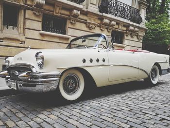 Side view of old car parked on street in city