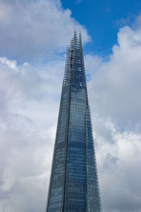 Low angle view of modern building against cloudy sky