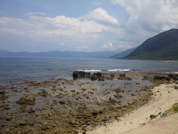 Scenic view of sea and mountains against sky