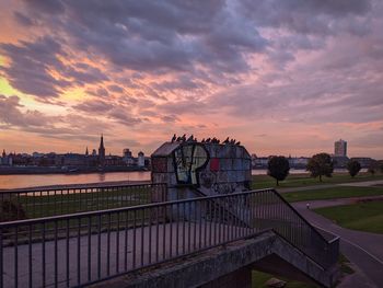 Bridge over river against cloudy sky during sunset