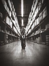 Rear view of woman walking in illuminated warehouse