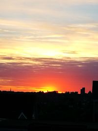 Silhouette cityscape against sky during sunset