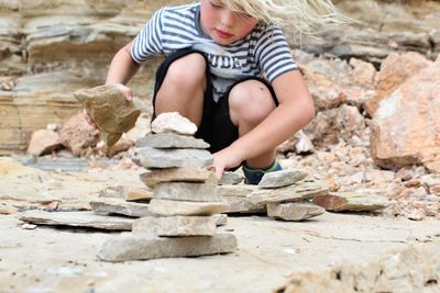 Boy making stack of stone