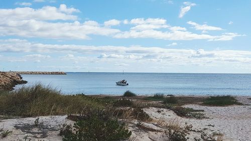 Scenic view of calm sea against cloudy sky