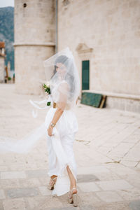 Full length of woman standing against white wall