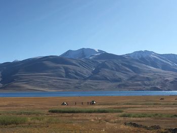 Scenic view of landscape and mountains against clear sky