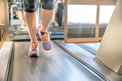 Low section of person running on treadmill in gym