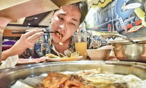 Portrait of man eating food in restaurant