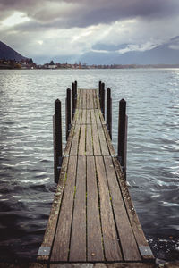 Wooden jetty in sea against sky