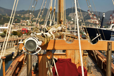 Close-up of sailboats moored on rope against sky