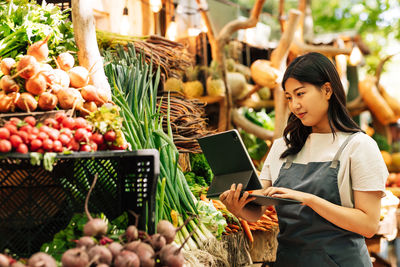 Midsection of woman using digital tablet