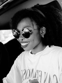 Smiling young woman wearing nose ring and sunglasses