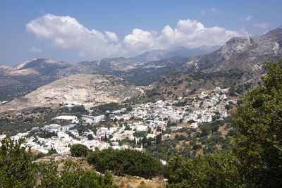 Aerial view of townscape and mountains against sky