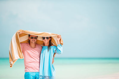 Woman standing by sea against sky