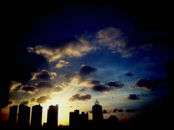 Low angle view of buildings against sky at sunset