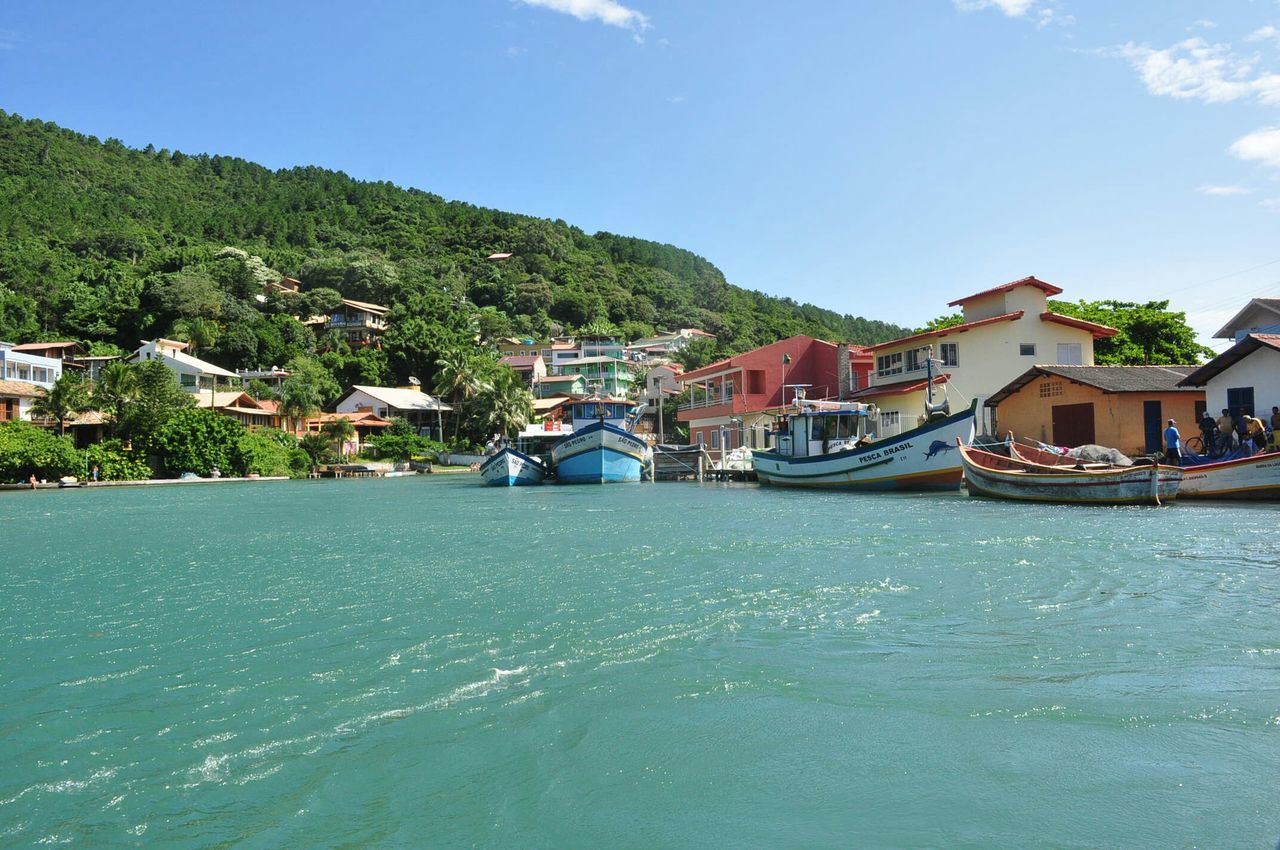 building exterior, water, architecture, built structure, mountain, nautical vessel, house, sea, waterfront, sky, town, boat, transportation, residential structure, mode of transport, residential building, tree, townscape, blue, moored