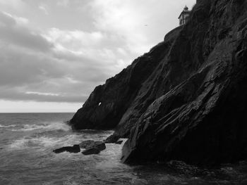 Rock formation on beach against sky