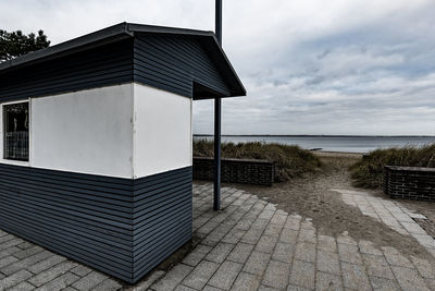 Built structure by sea against sky