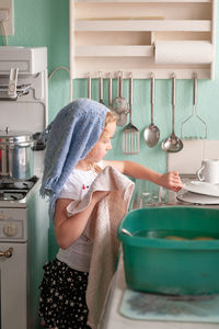 Side view of woman standing at home