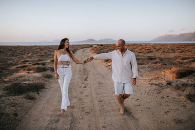 Friends standing on land against sky