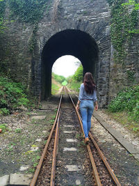 Rear view of man standing on railroad track