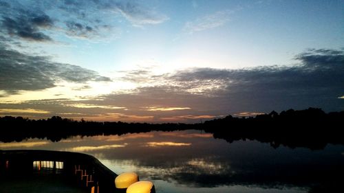 Reflection of clouds in calm lake at sunset